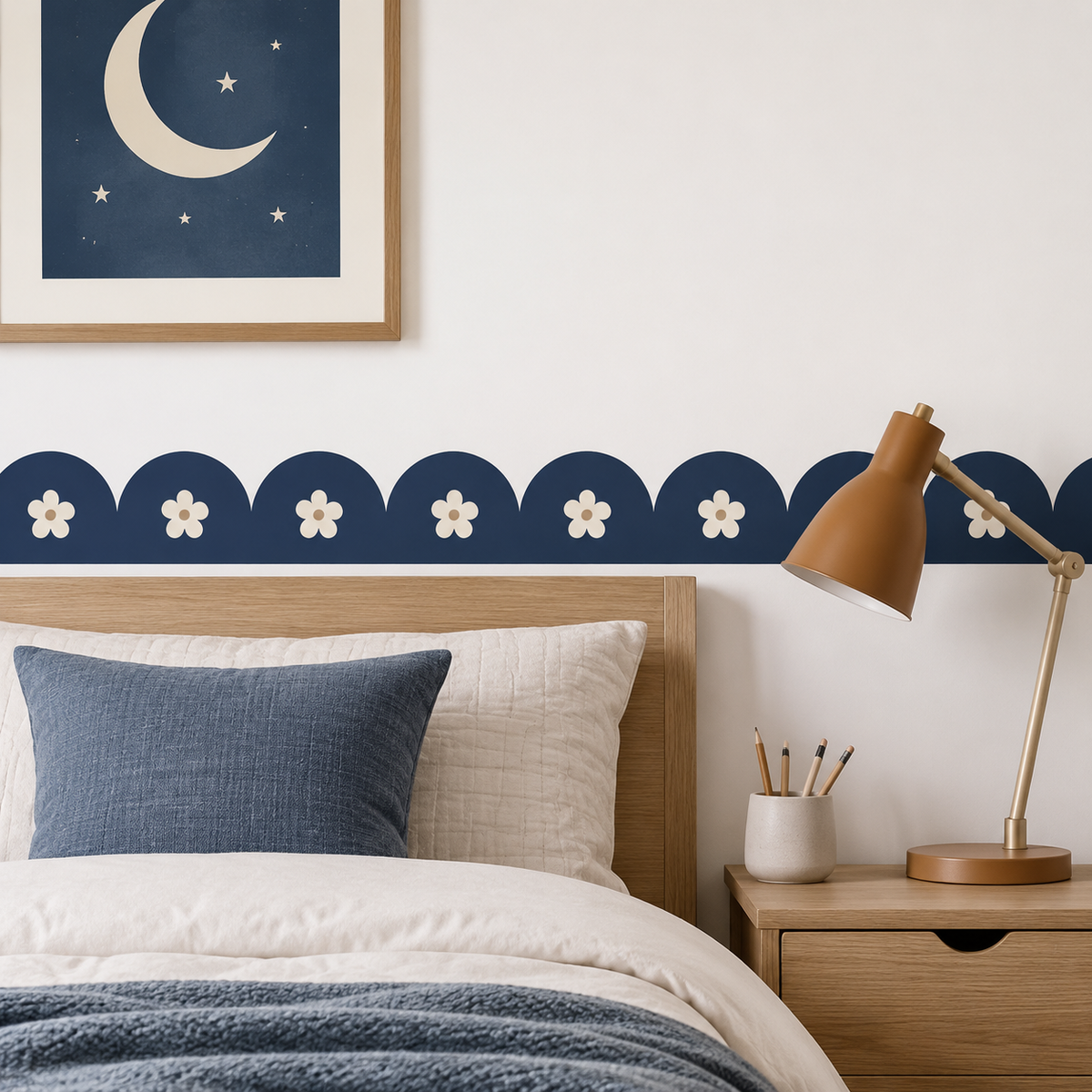 Navy Blue daisy scalloped peel-and-stick wallpaper border above a wooden bed, styled with moon artwork and a brass lamp.