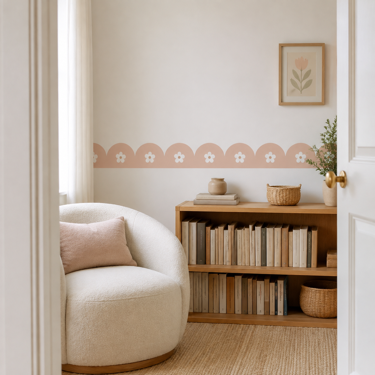 Peach Blush daisy scalloped peel-and-stick wallpaper border in a reading corner with a cream armchair and wooden bookshelf.